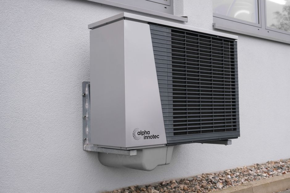 Clean outdoor AC condenser unit installed on the exterior of a residential home