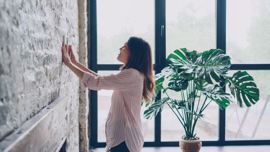 Homeowner adjusting a smart thermostat for precise temperature control